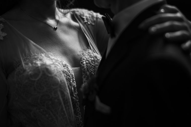 Sesja ślubna w Palmiarni Gliwice – detal sukni ślubnej i bukietu wśród zieleni